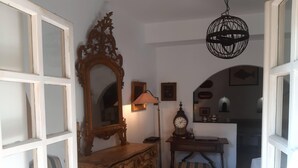 A room with a wooden dresser, a mirror, a lamp, a clock, and a small table with a lamp. - The traveler's choice (Genova)