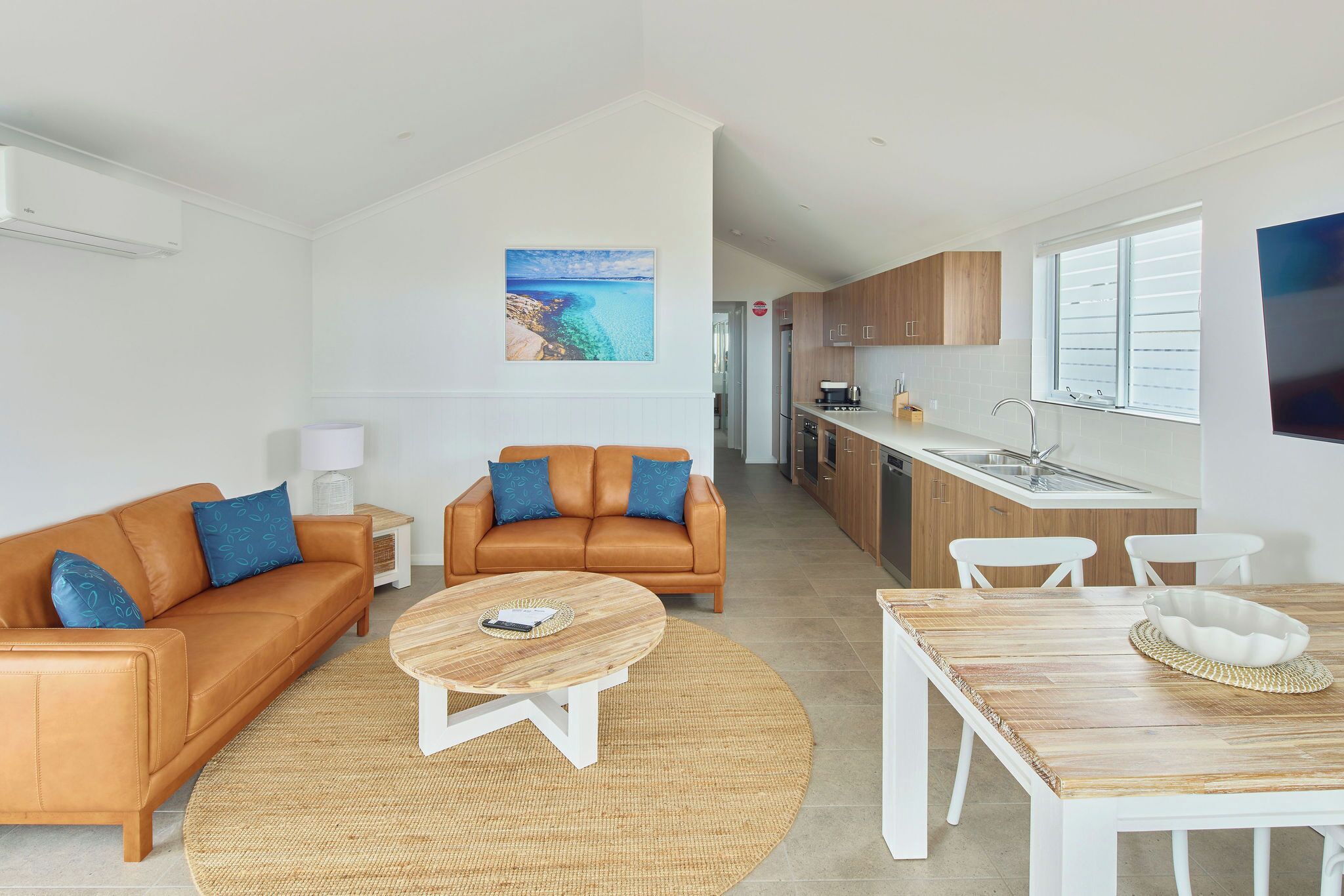 A modern living room with two sofas, a coffee table, and a dining table.
