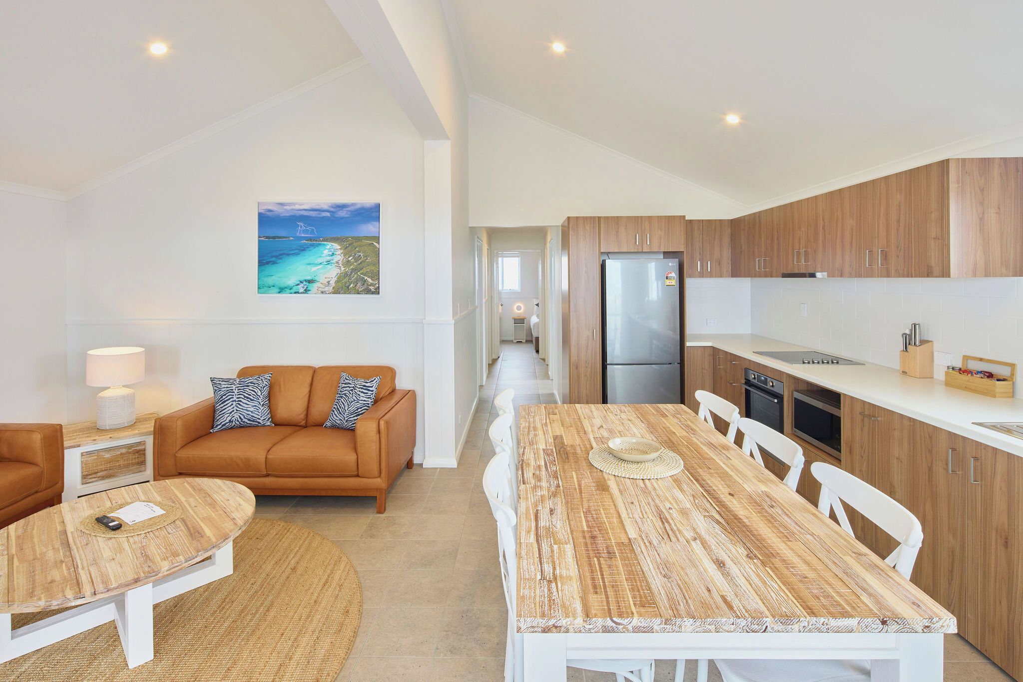 Eine moderne Küche mit Holzschränken und einem Edelstahlkühlschrank.