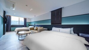 A modern hotel room with two beds, a sofa, a small table, and a view of the city. - Wonju Central Hotel (Wonju)