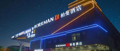 A hotel named Borrman with illuminated signage and a modern facade.