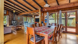 A spacious kitchen with a brick wall, a built-in oven, and a dining area with a table and chairs.