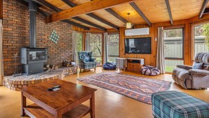 A cozy living room with a fireplace, a television, and comfortable seating.