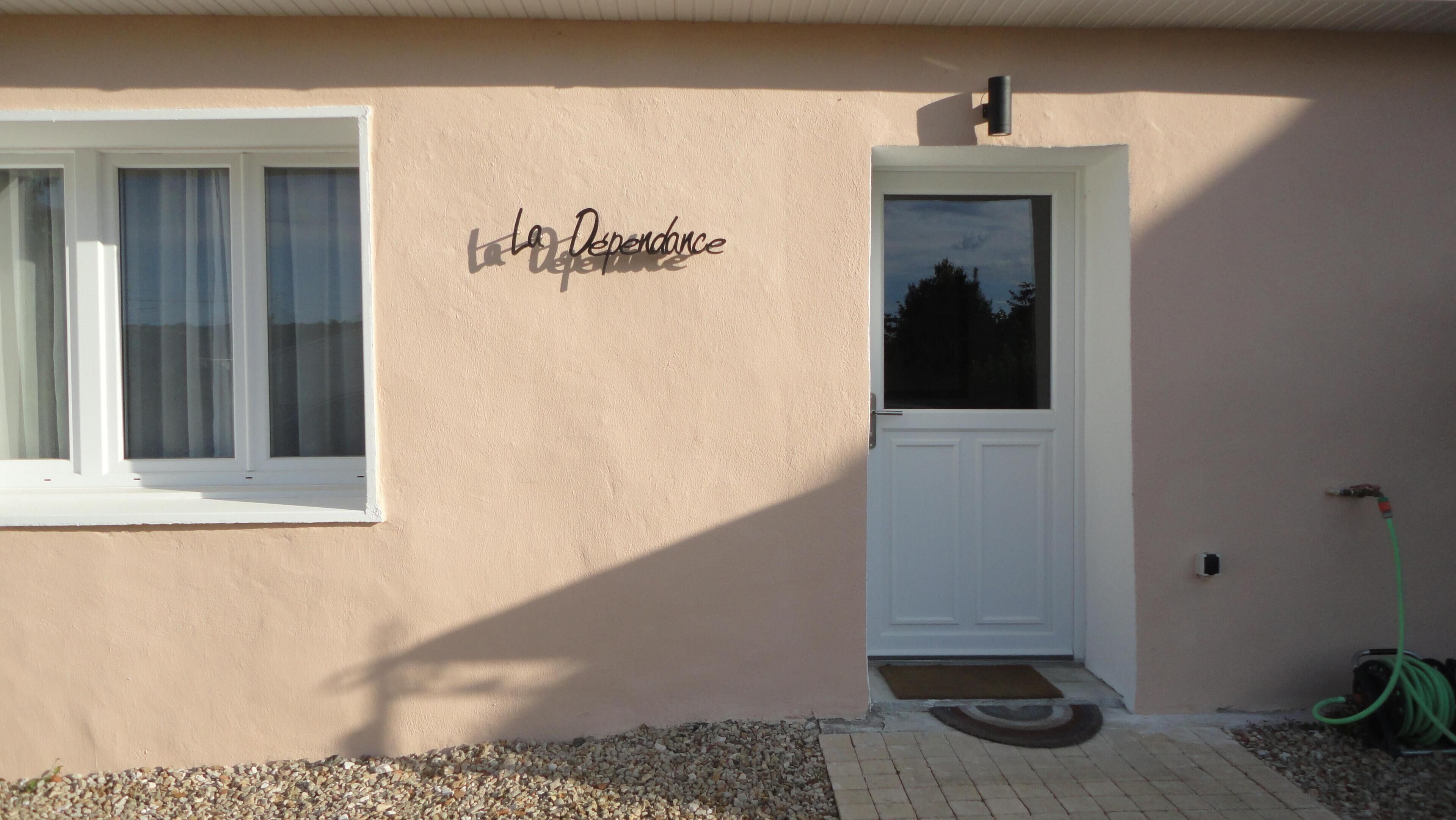 Une façade d’immeuble avec une porte blanche et une fenêtre ornée de rideaux.