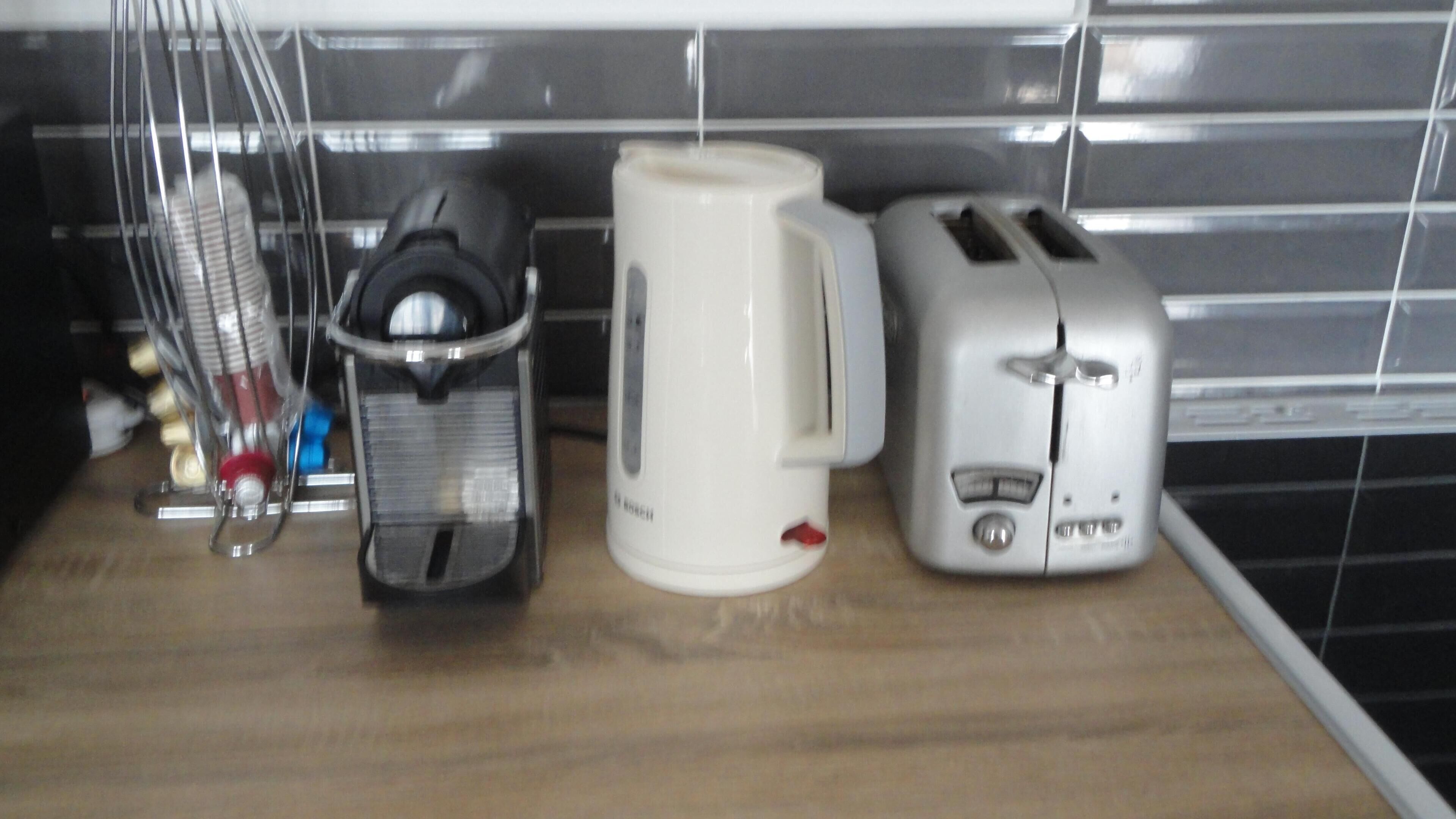 Eine Küchenarbeitsplatte mit Kaffeemaschine, Toaster und Wasserkocher.