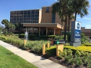 A hotel with a modern building, a landscaped garden, and a sign indicating it is part of the Best Western hotel chain. - Best Western Orlando Gateway Hotel (Orlando)