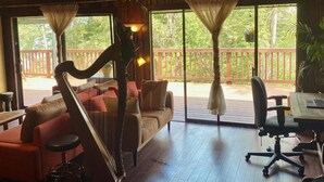 Une pièce comprenant une harpe, un canapé, un bureau et une chaise.