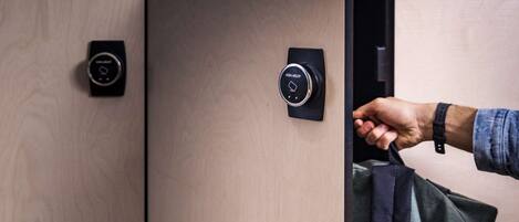 A person opening a wooden wardrobe with a digital lock.