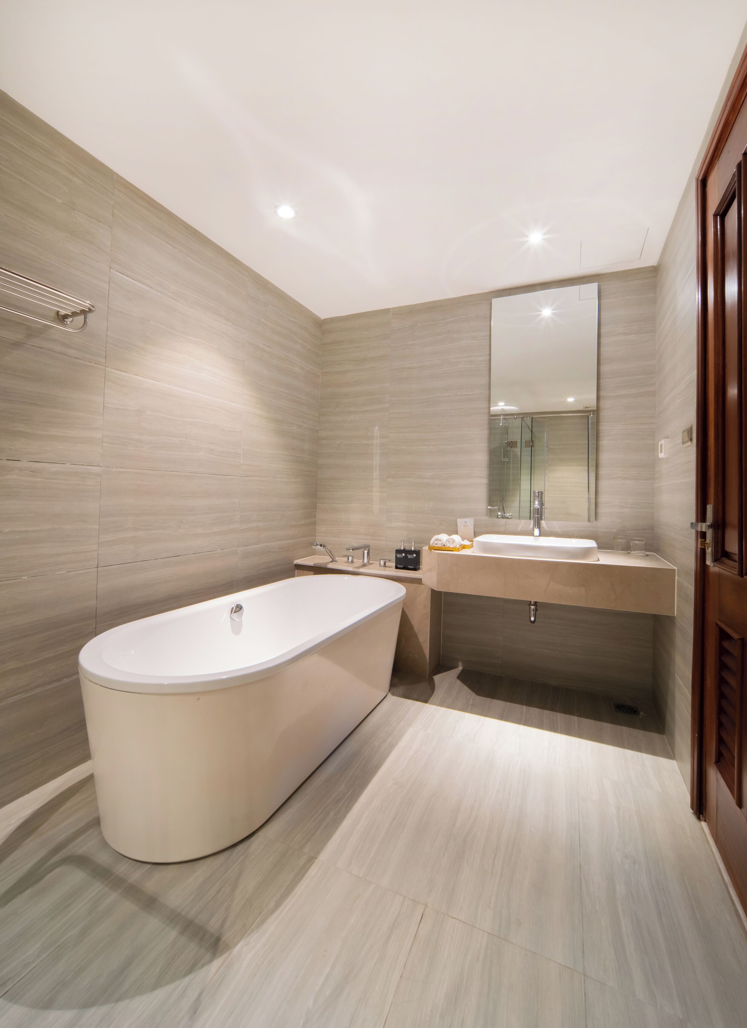 A modern bathroom with a freestanding bathtub, a vanity with a mirror, and a shower area.