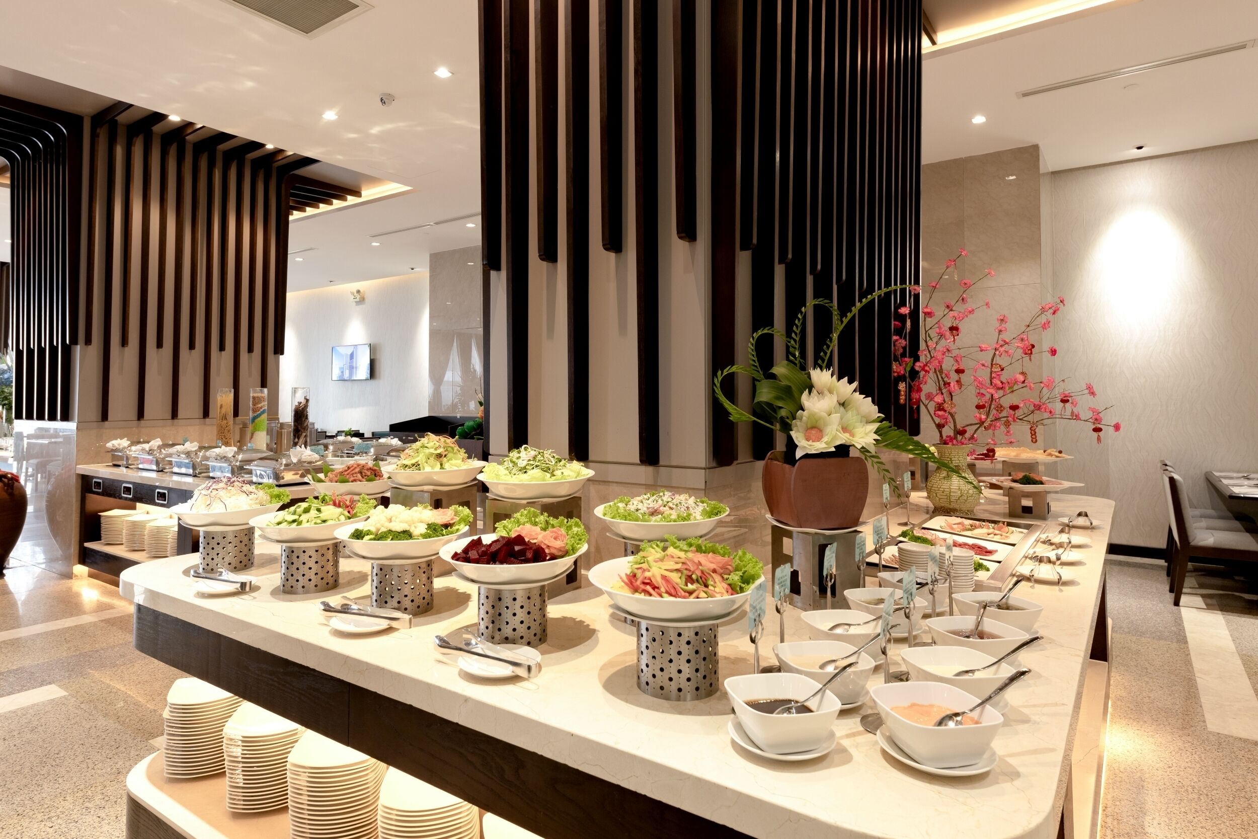 A buffet setup with various food items and serving utensils.
