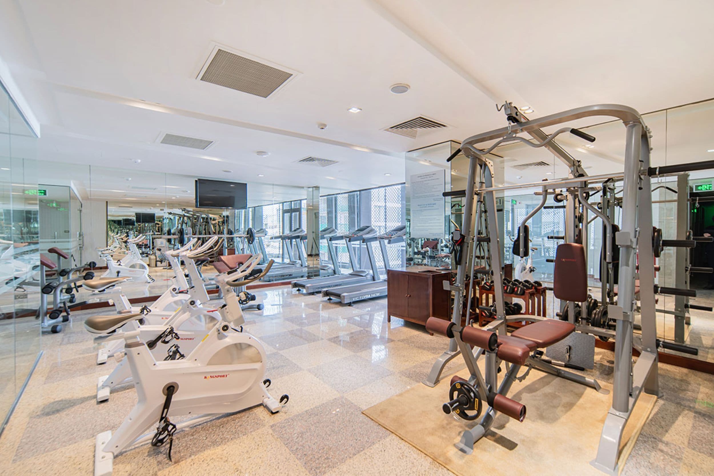 Een moderne sportschool met diverse fitnessapparaten, waaronder loopbanden en krachtapparaten.