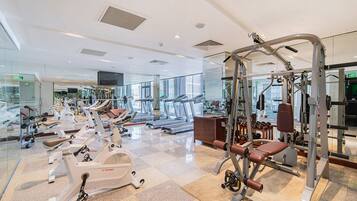 A modern gym with various exercise equipment, including treadmills and weight machines.