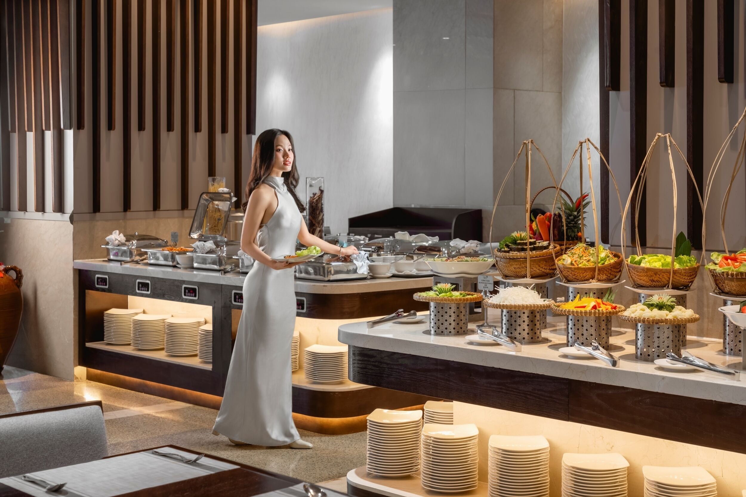 Un buffet avec différents stands de nourriture et une personne qui sert les plats.