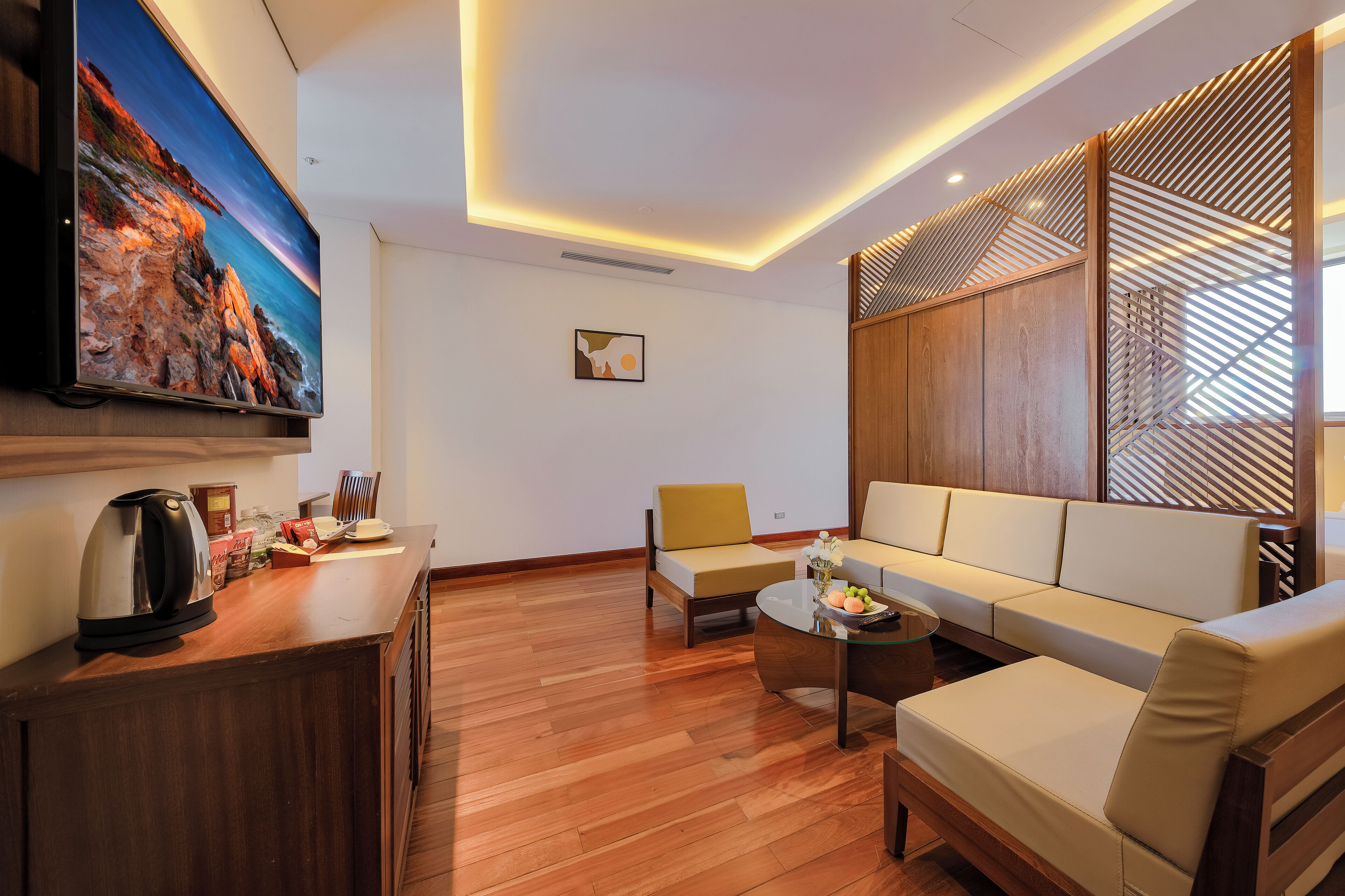 Un salon moderne avec un téléviseur à écran plat, des meubles en bois et un canapé.