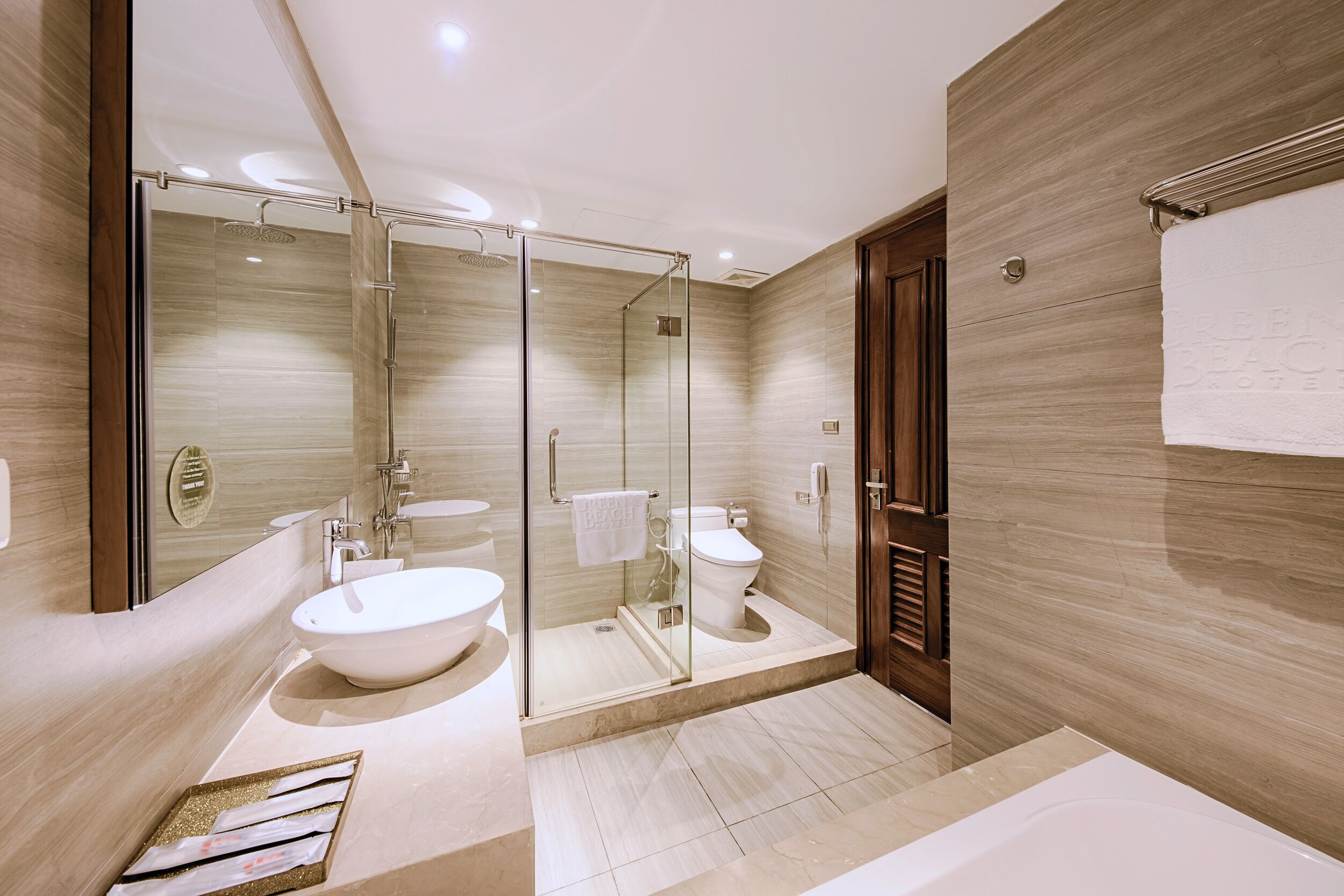 Une salle de bain moderne avec une douche à parois de verre, un grand lavabo et des toilettes.