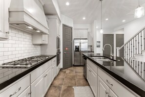 Enjoy cooking in this well-equipped kitchen with a range, double oven, and refrigerator.