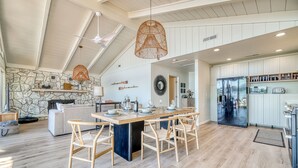 Una cocina amplia con una isla central, pared de piedra y electrodomésticos modernos.
