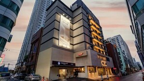 A multi-story hotel with a modern design, featuring a prominent entrance and signage for a restaurant. - Hotel Foret The Spa (Busan)