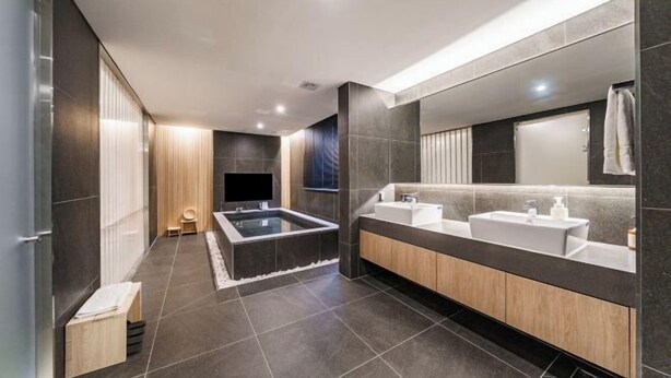 A modern bathroom with a large bathtub, two sinks, and a mirror. - Hotel Foret The Spa (Busan)