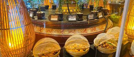 A buffet setup with covered food containers and a decorative centerpiece.
