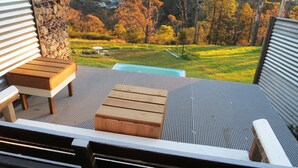 An outdoor deck with a wooden bench, a small table, and a pool. - Sleep in the Clouds! The Haiku Hut... (Wentworth Falls)