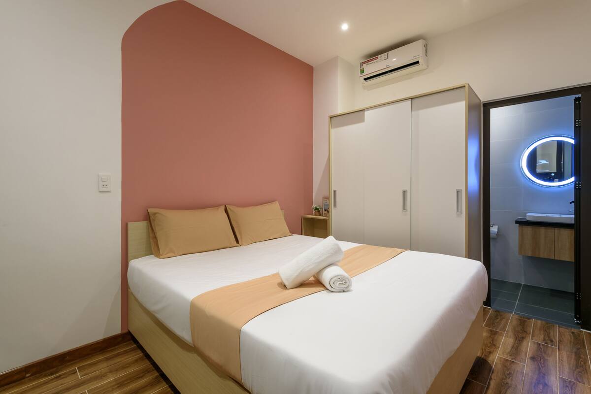 Een hotelkamer met een bed, een kledingkast, een spiegel en een airconditioning.