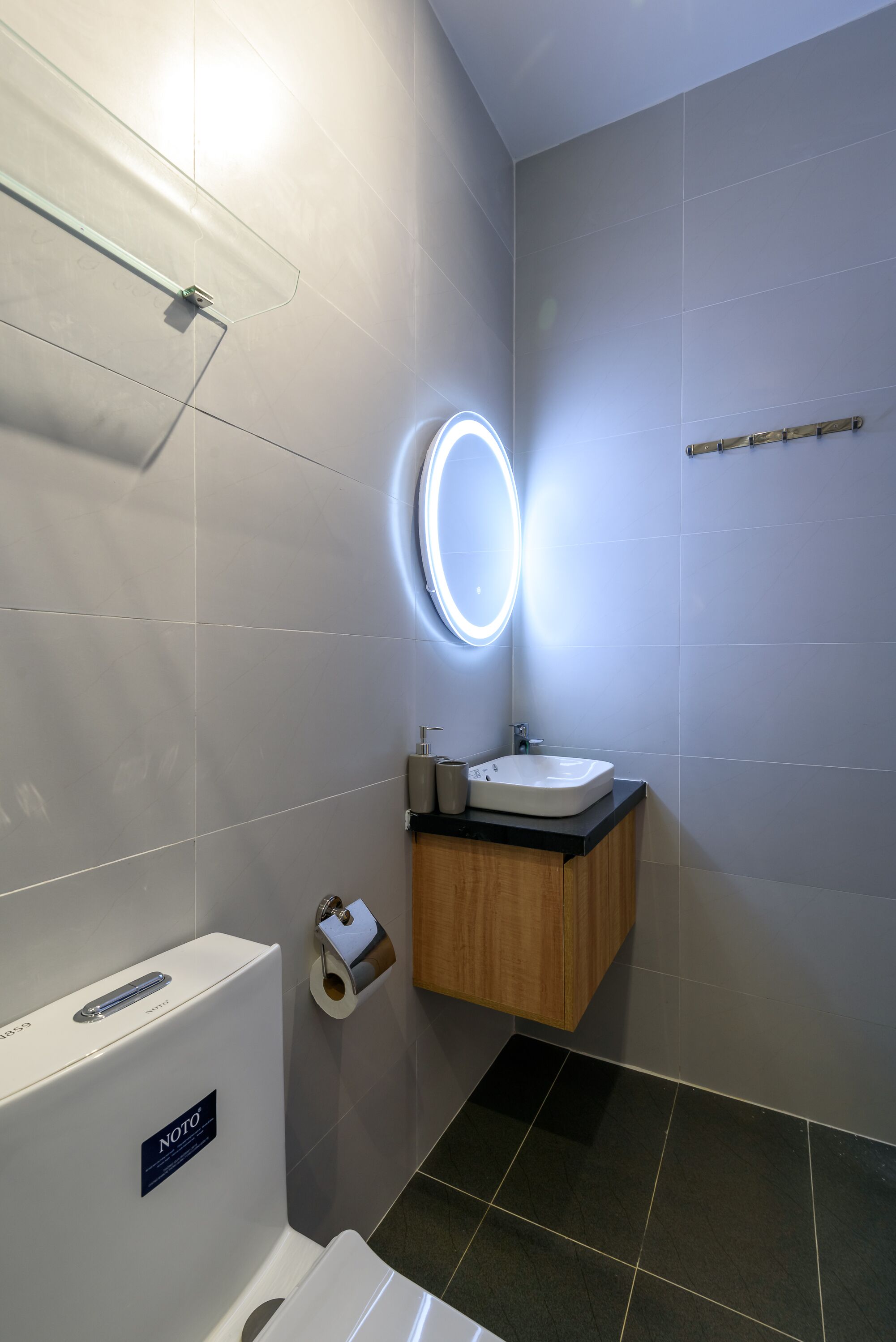 A modern bathroom with a toilet, sink, and mirror.
