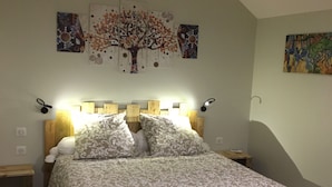 A bedroom with a bed, two bedside tables, a nightstand, and a wall with three paintings. - Gîte "La Hulotte" country property away from the city (Villeneuve-la-Lionne)