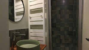 A bathroom with a large green basin, a modern faucet, a mirror, and a shower with a checkered tile wall. - Gîte "La Hulotte" country property away from the city (Villeneuve-la-Lionne)