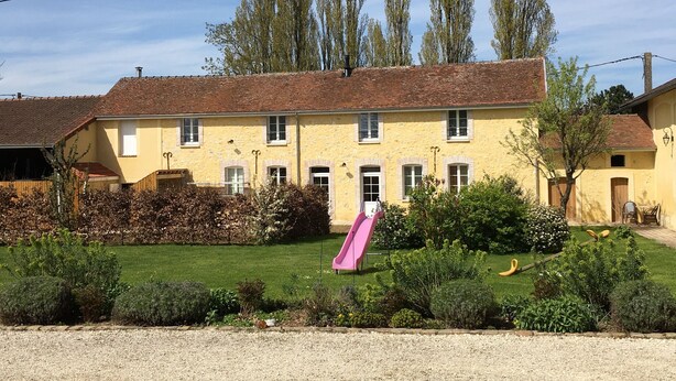 A yellow building with a red roof, a pink slide, and a gravel path in front. - Gîte "La Hulotte" country property away from the city (Villeneuve-la-Lionne)