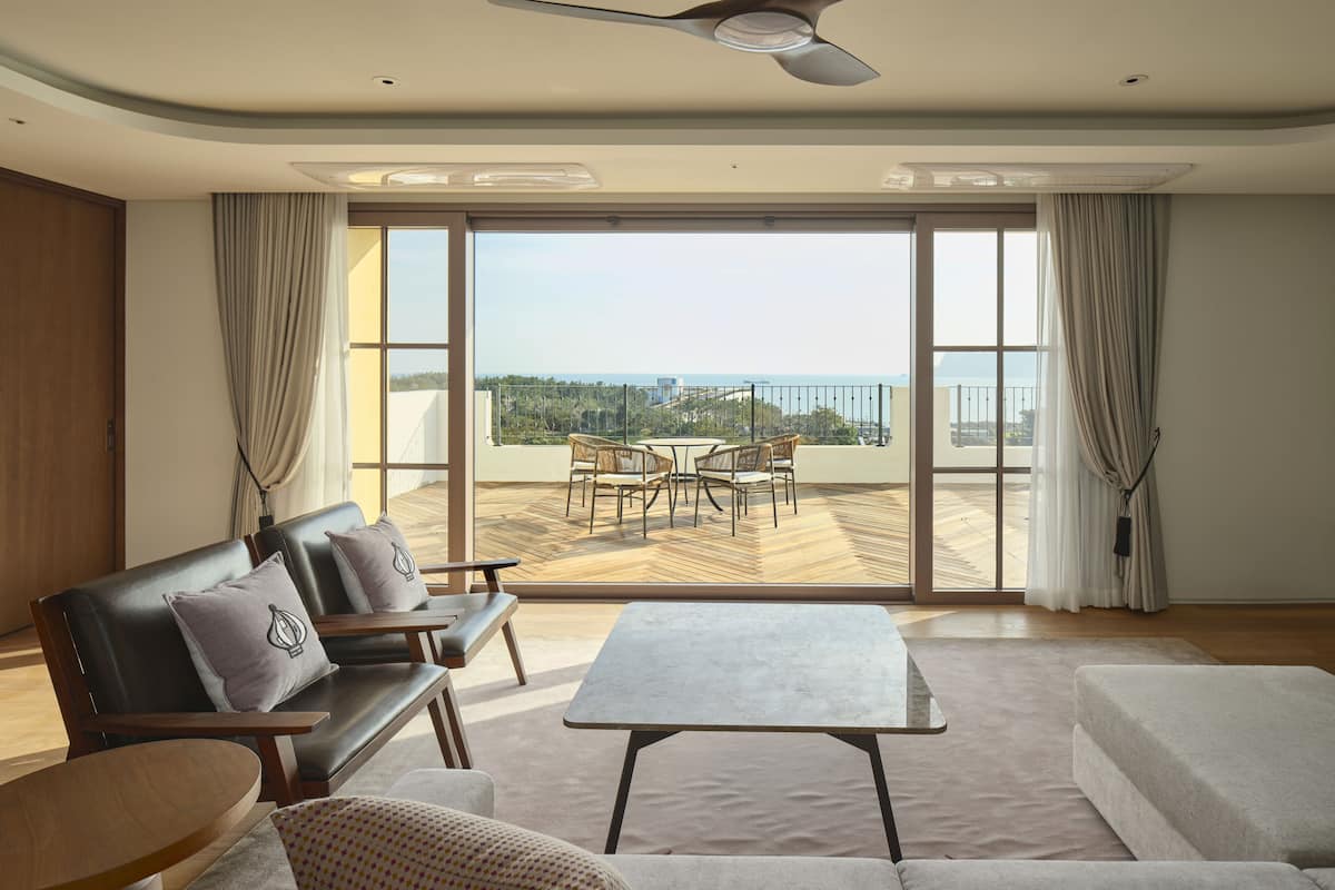 A spacious living room with a large sliding glass door leading to an outdoor terrace.