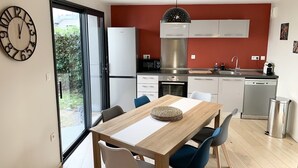 A modern kitchen with white cabinets, a stainless steel range hood, and a dishwasher.