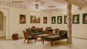 A traditional living room with a sofa set, a coffee table, and a decorative column.