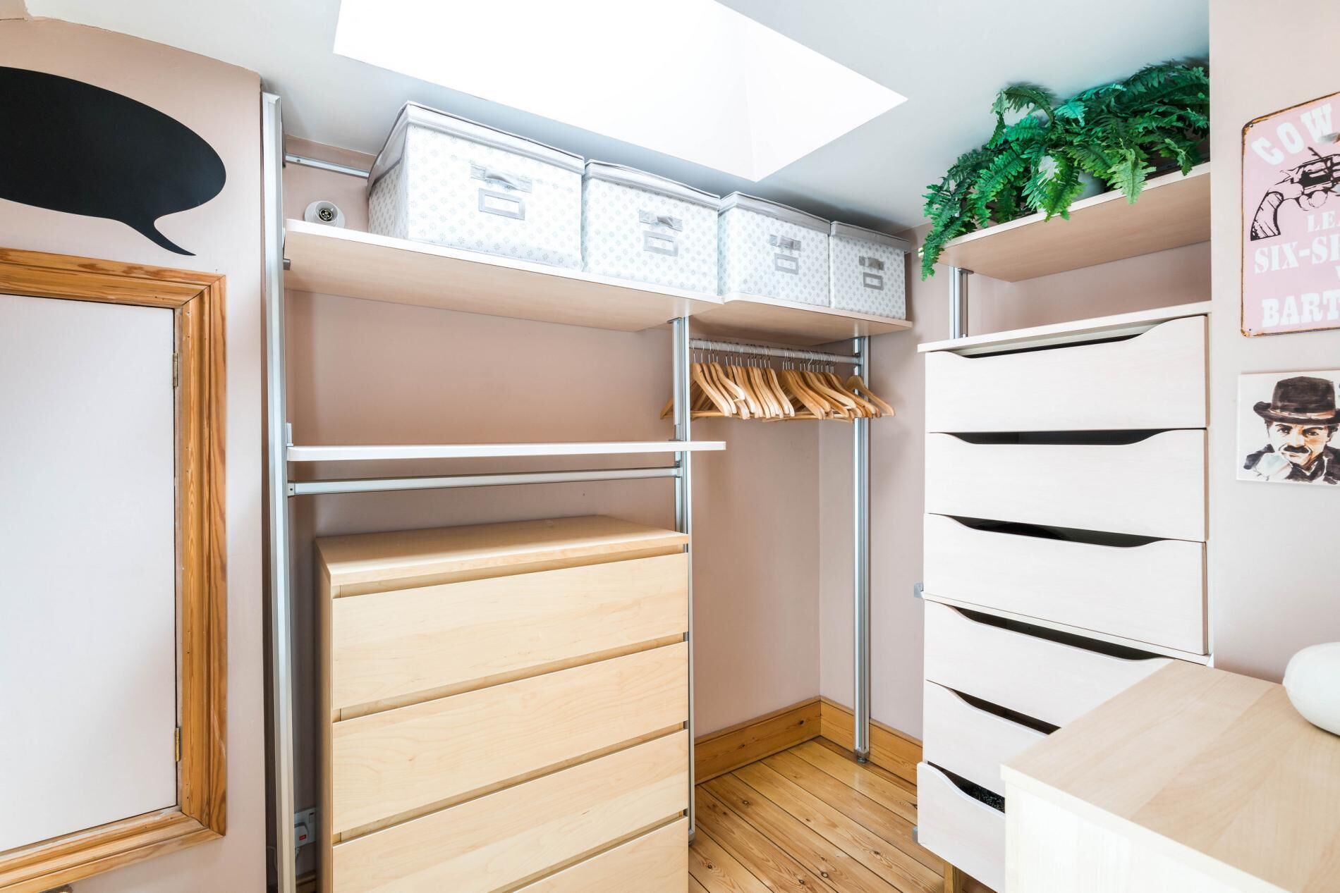 Un vestidor amplio con estantes abiertos, un banco de madera y una barra para colgar ropa.