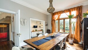 A dining area with a wooden table, chairs, and a chandelier.