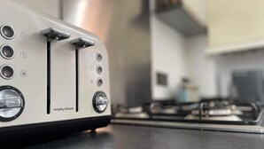 A kitchen with a white toaster on a countertop, a stove, and a sink. - 2 Bed Self Contained Apartment Wrexham (Wrexham)