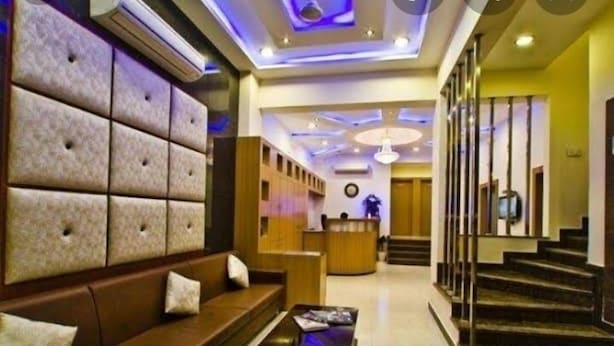 A lobby with a reception desk, a sofa, and a staircase. - Hotel Durga Silverline (Jodhpur)