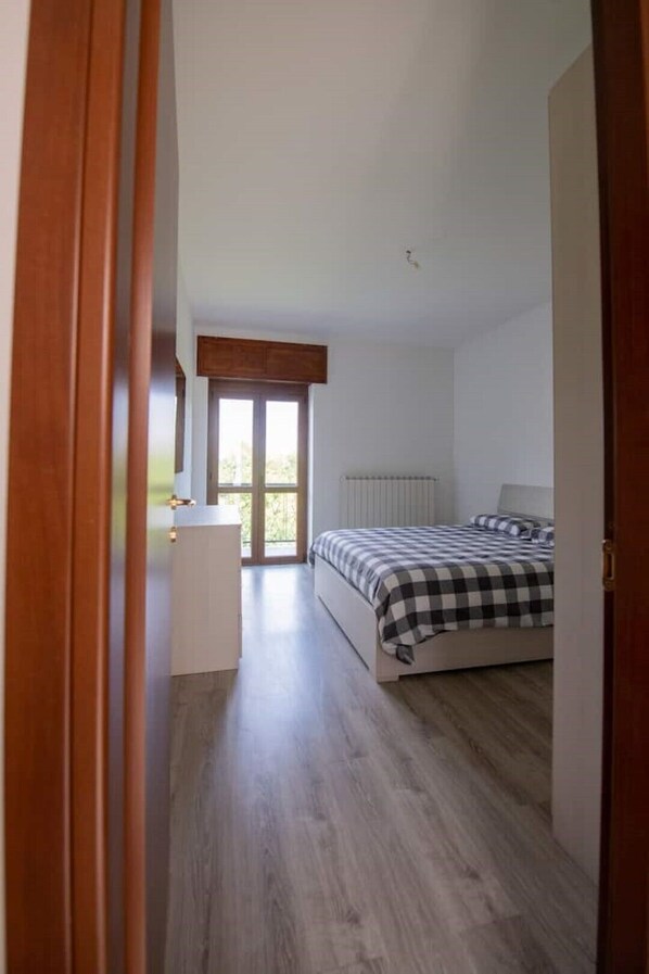 A bedroom with a bed, a radiator, and a view through a door. - Welcome home 2 Rocciamelone view (Meana Di Susa)