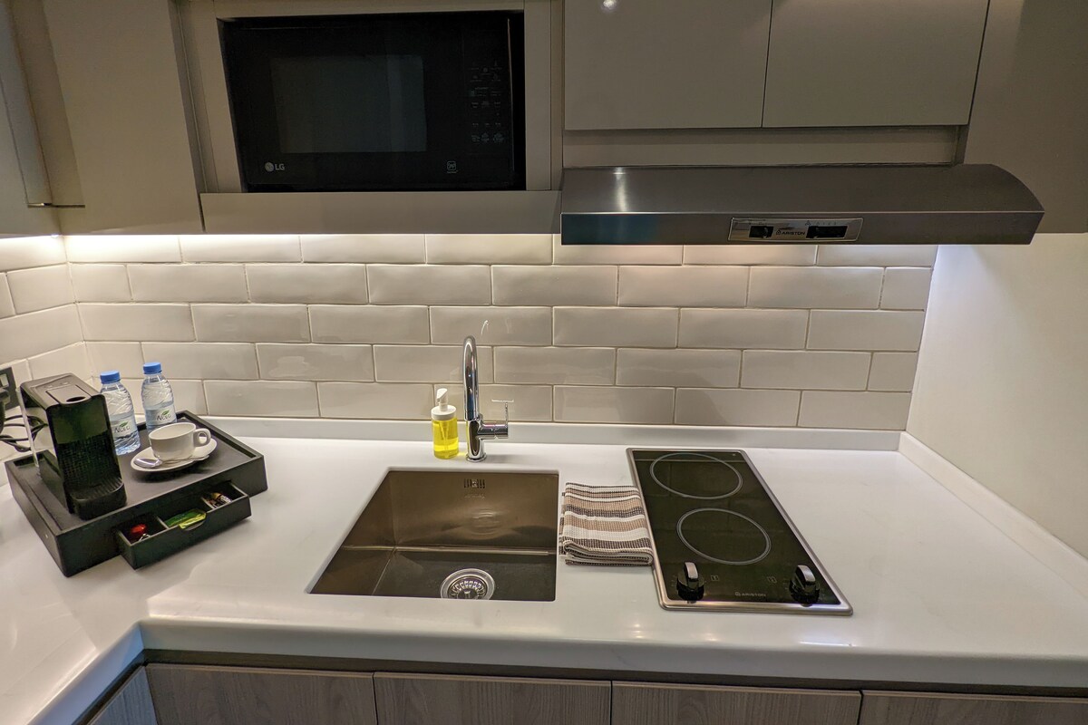 A modern kitchen with a built-in microwave, stainless steel range hood, and a double electric stove.