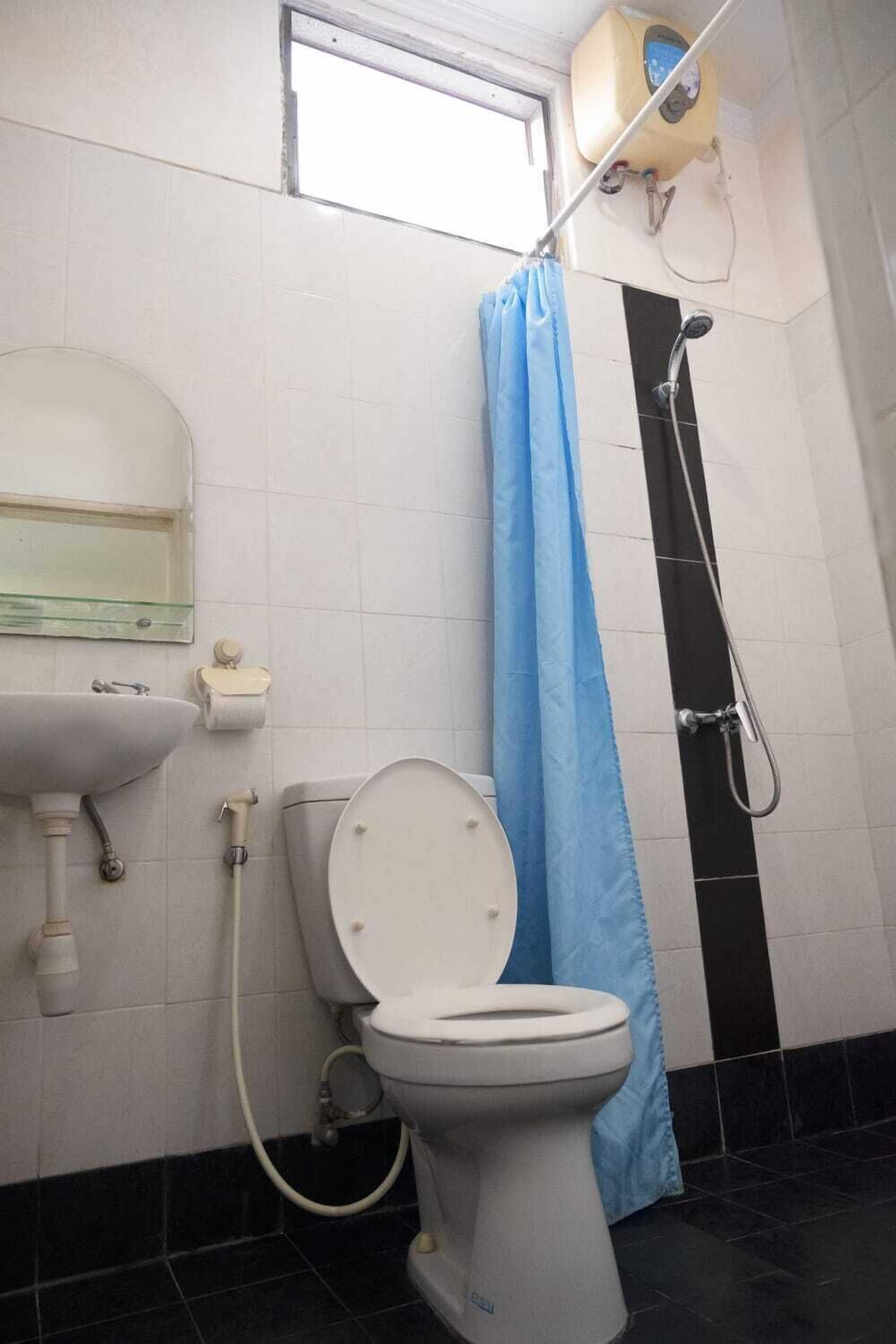 Une salle de bain avec des toilettes, un lavabo et une douche.
