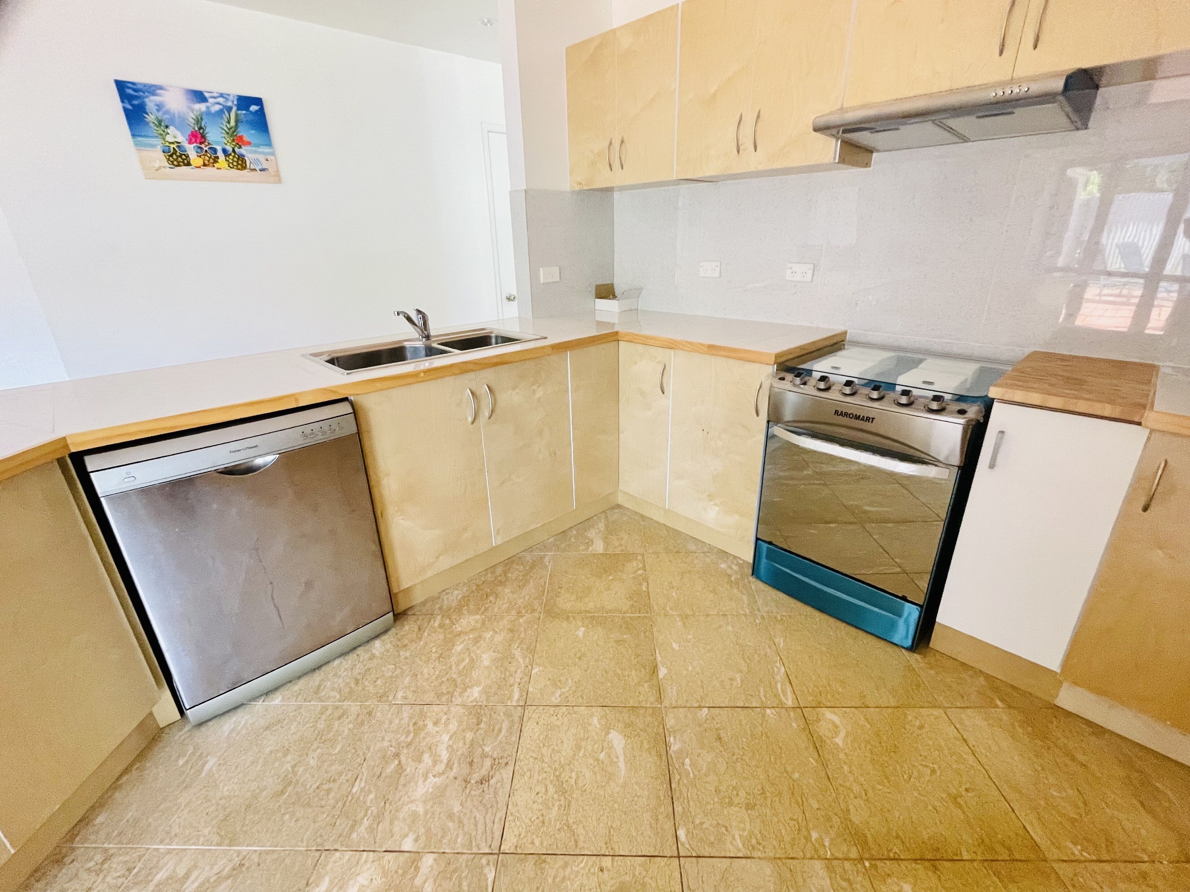 A kitchen with a dishwasher, stove, and cabinets.