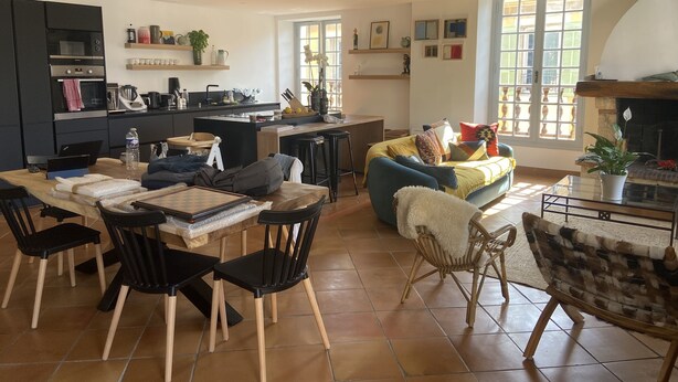Un grand espace de vie comprenant une cuisine, une table à manger et un coin salon.