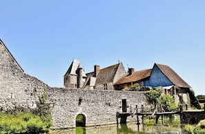 Un edificio histórico de piedra con un gran arco y un puente sobre el agua.