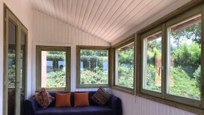 A room with a blue sofa, two windows, and a view of greenery. - Charming 3 Bed Villa in Otricoli Stunnings Views (Otricoli)
