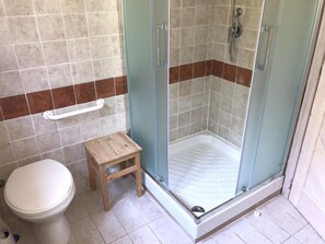 A bathroom with a glass-enclosed shower, a white toilet, and a small wooden stool. - Charming 3 Bed Villa in Otricoli Stunnings Views (Otricoli)