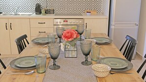 A dining table set with plates, glasses, and a centerpiece.