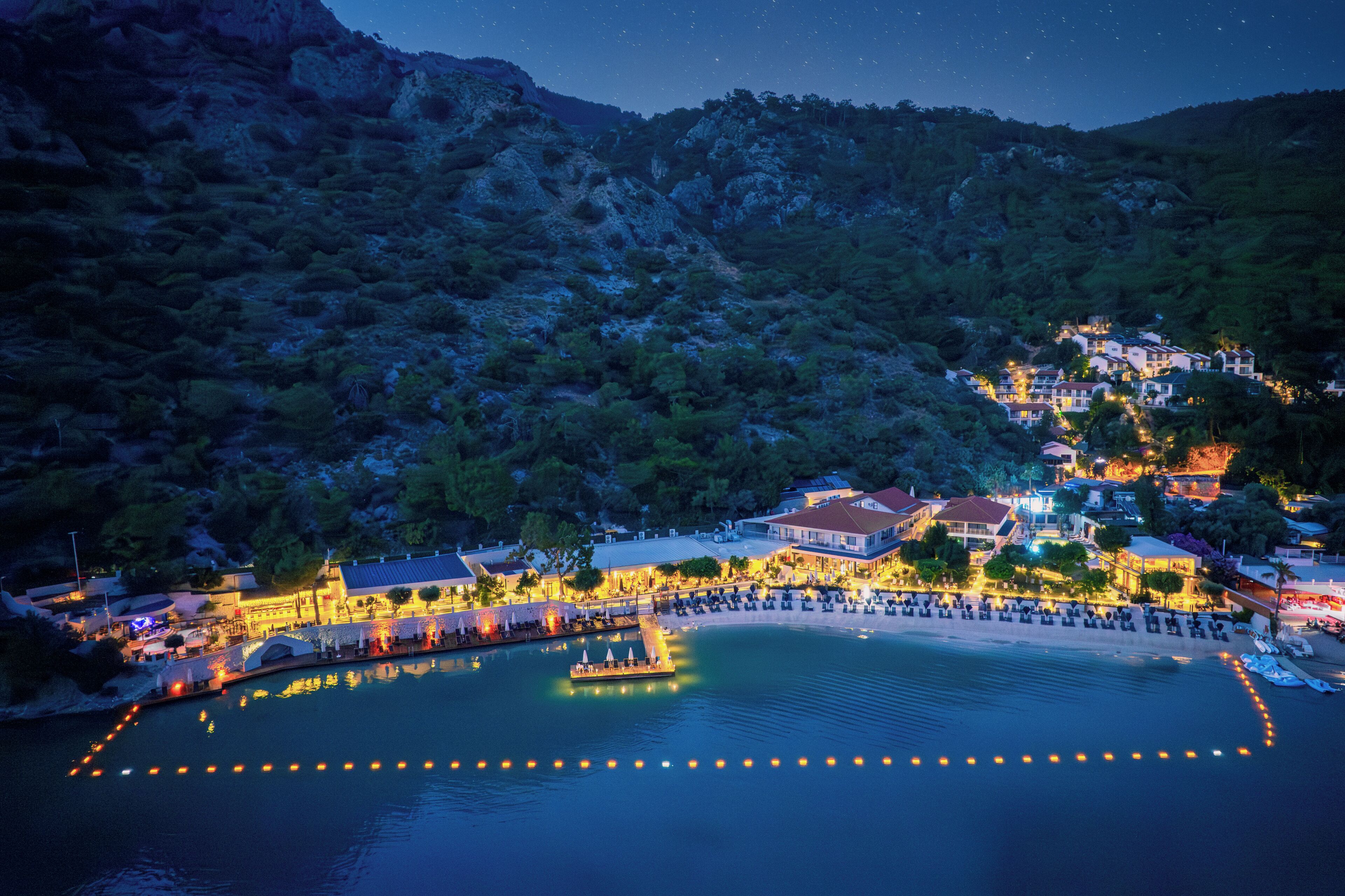 A coastal town with buildings, a waterfront promenade, and a boat dock.