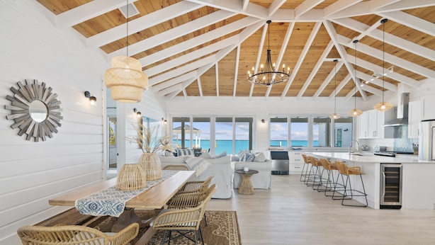 A spacious kitchen with a large island, wooden ceiling beams, and a view of the ocean. - Casa Mary : The Ultimate Luxury Beachfront Home in the Exumas (Jimmy Hill)