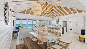 A spacious kitchen with white cabinets, a wooden ceiling, and a view of the ocean. - Casa Mary : The Ultimate Luxury Beachfront Home in the Exumas (Jimmy Hill)