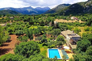 A villa with a swimming pool surrounded by lush greenery and mountains in the background. - Finca Puna with pool, quiet location, A/C, Wifi, 7 km to the beach (IB)